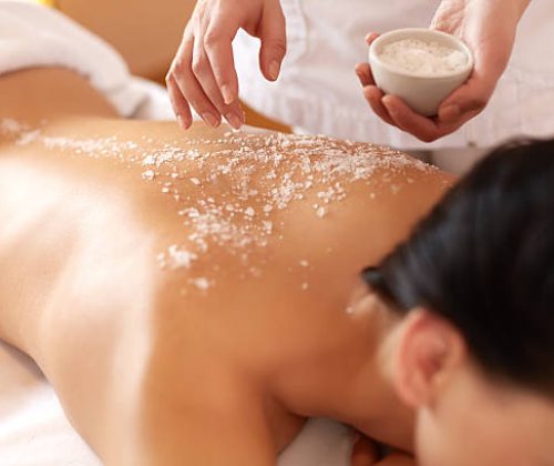 Spa Woman. Brunette Getting a Salt Scrub Beauty Treatment in the Health Spa. Body Scrub.